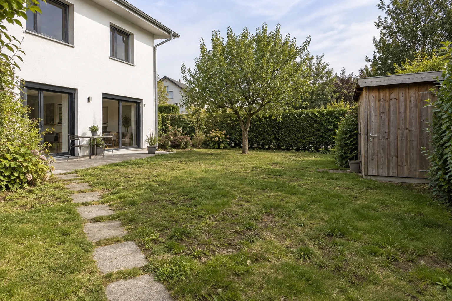 Garten mit lückigem Rasen und alten Trittplatten